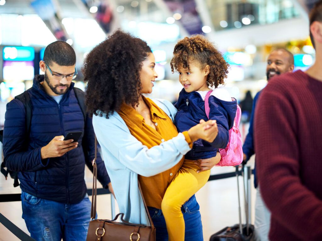 Mom holding toddler in airport line