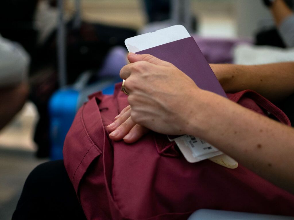 Passenger sitting with passport and boarding pass in hand