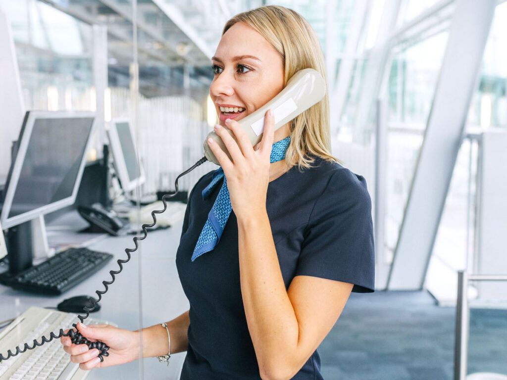 Gate agent at podium speaking on phone