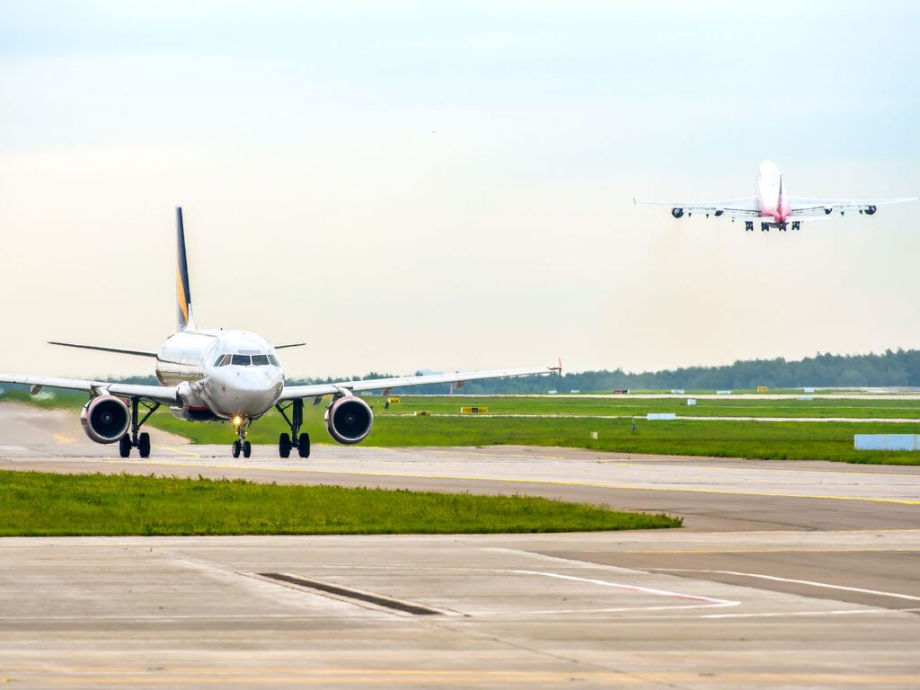 Aircraft taxiing to runway as another departs