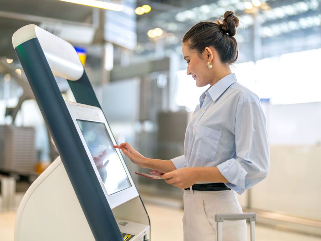 Passenger using check-in kiosk at airport