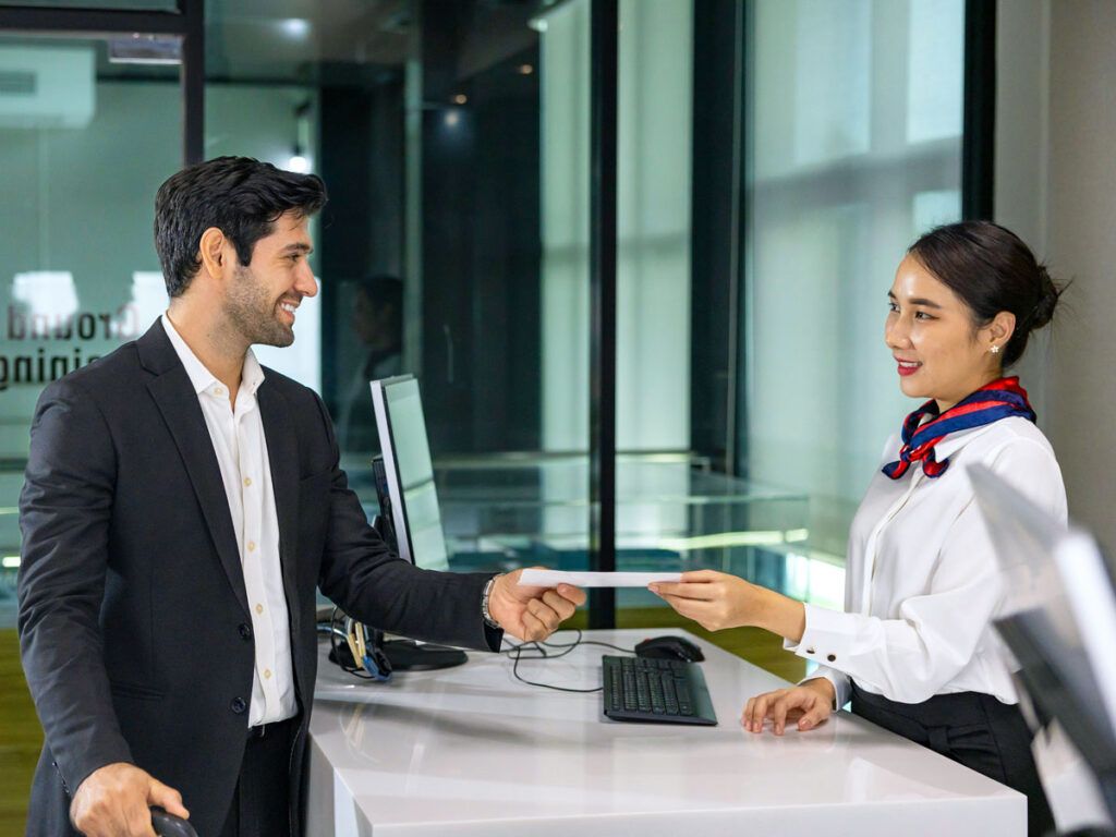 Passenger handing boarding pass to gate agent