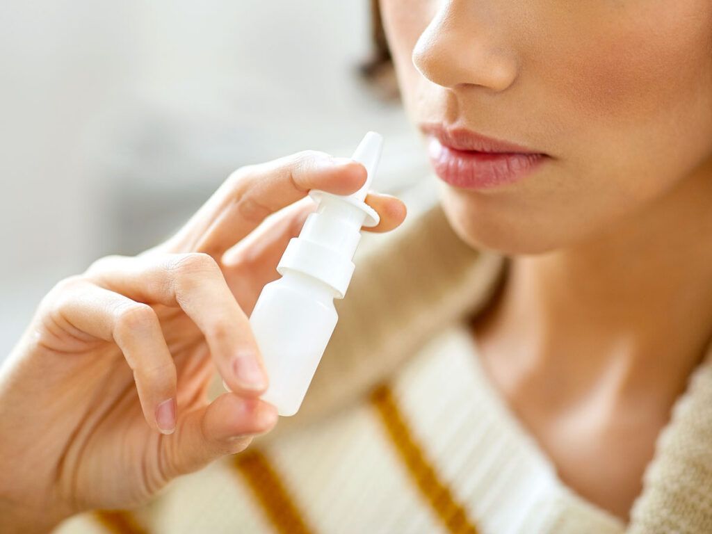 Person using saline nose spray