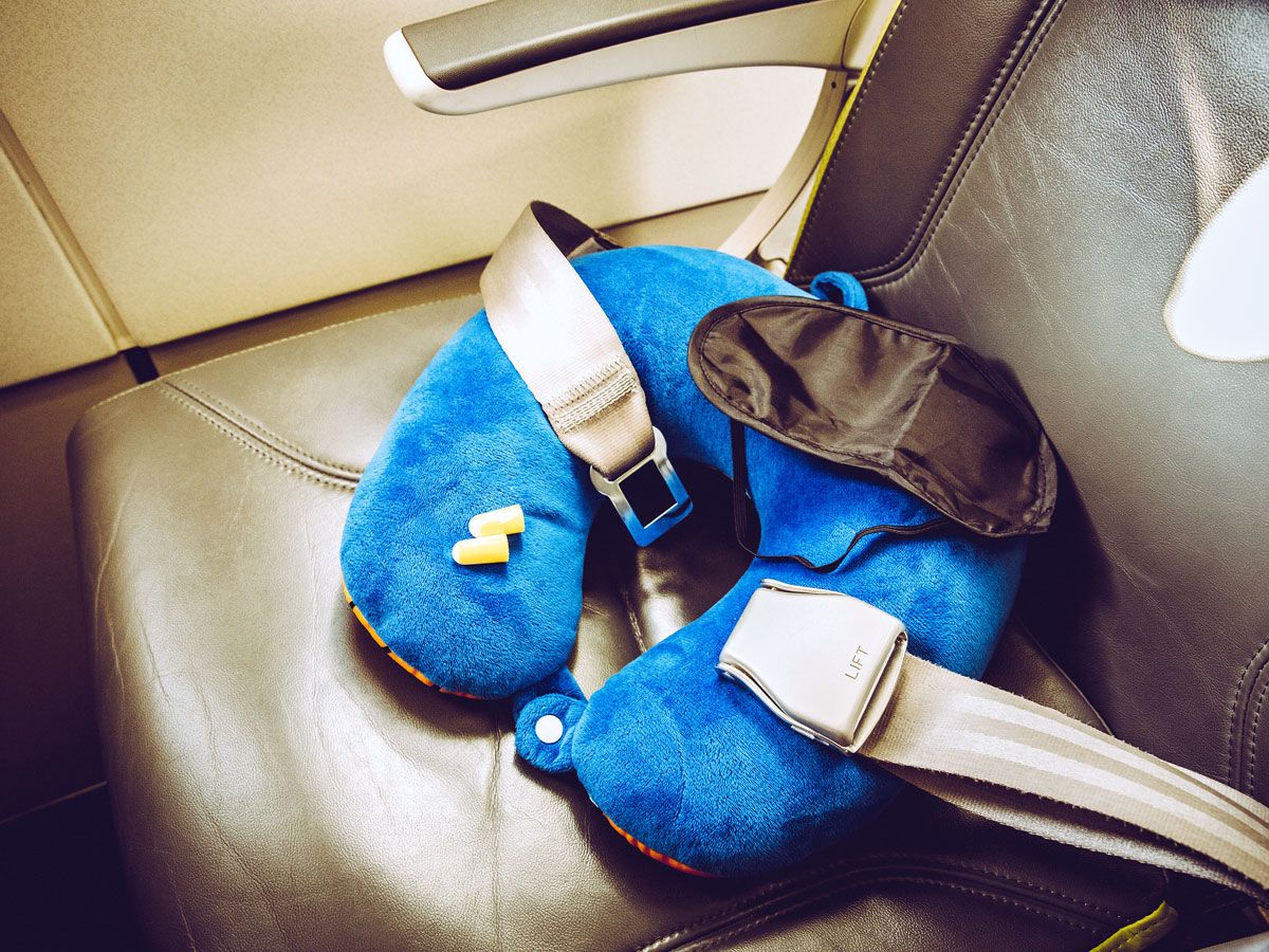 Neck pillow, eye shades, and ear plugs on airplane seat