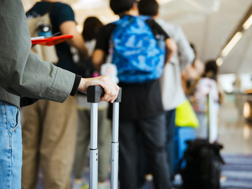 Travelers standing in airport queue