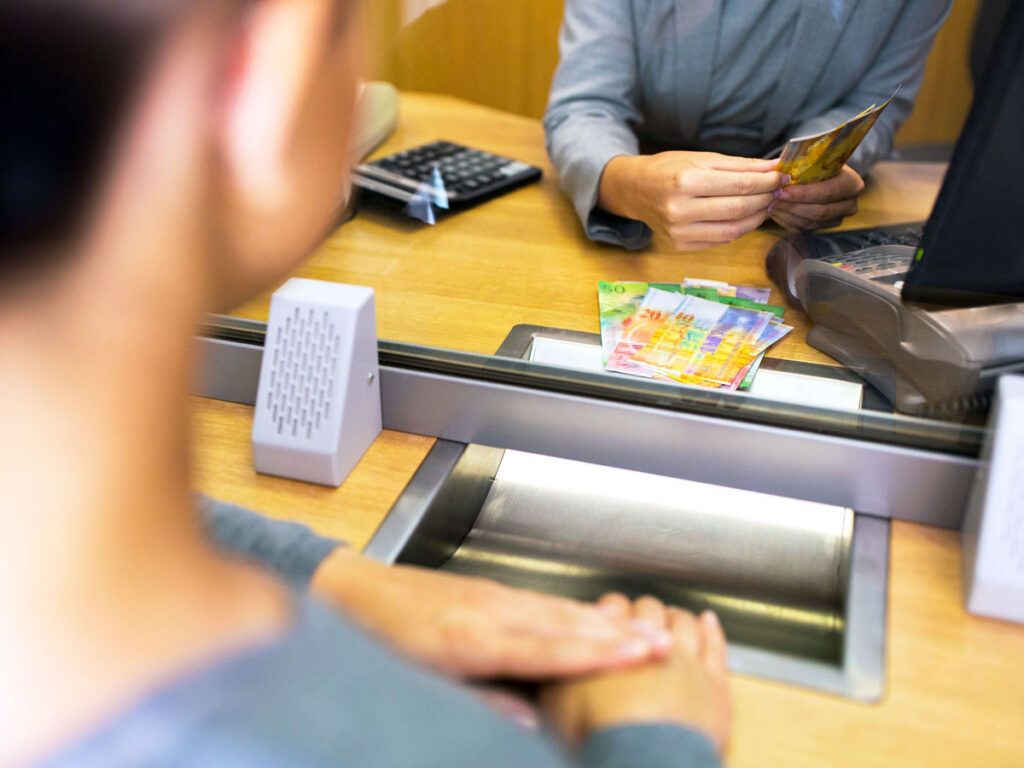 Clerk counting cash at bank