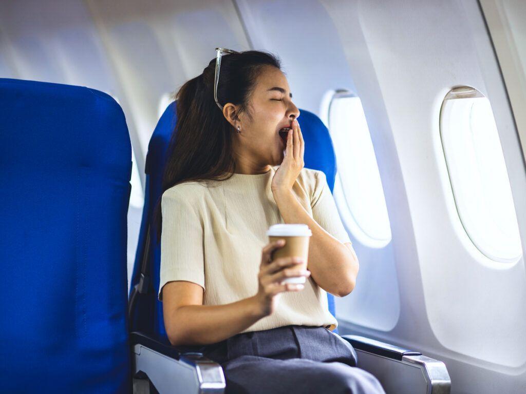 Passenger yawning in window seat
