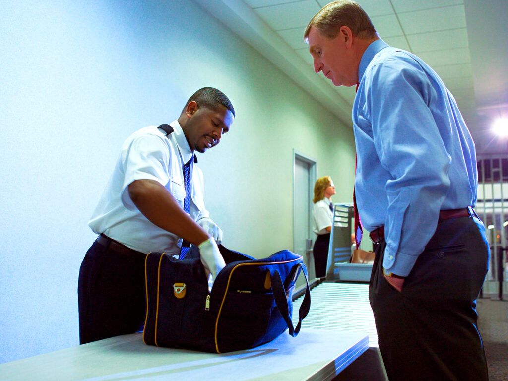 Security officer examining contents of traveler's bag